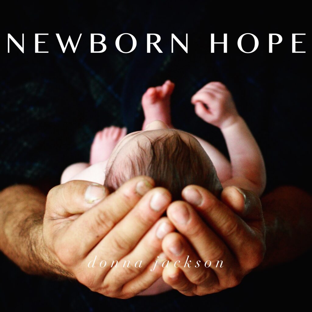 A person holding a baby in their hands.