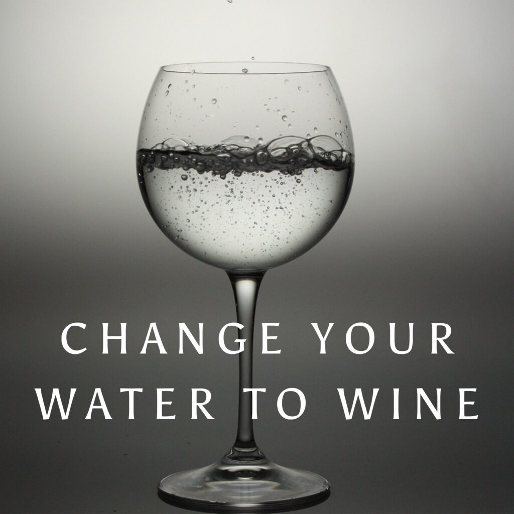 A glass of water with the words " change your water to wine ".