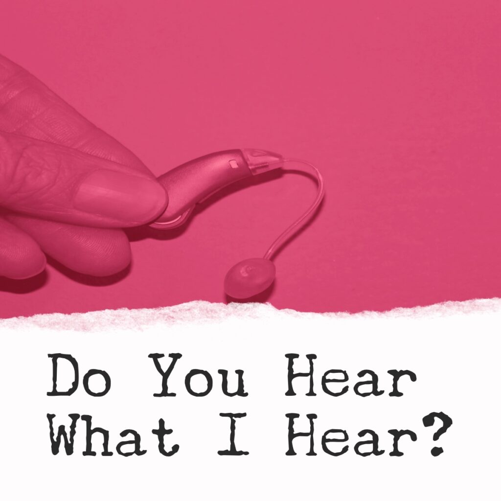 A hand is holding up a pair of earbuds.